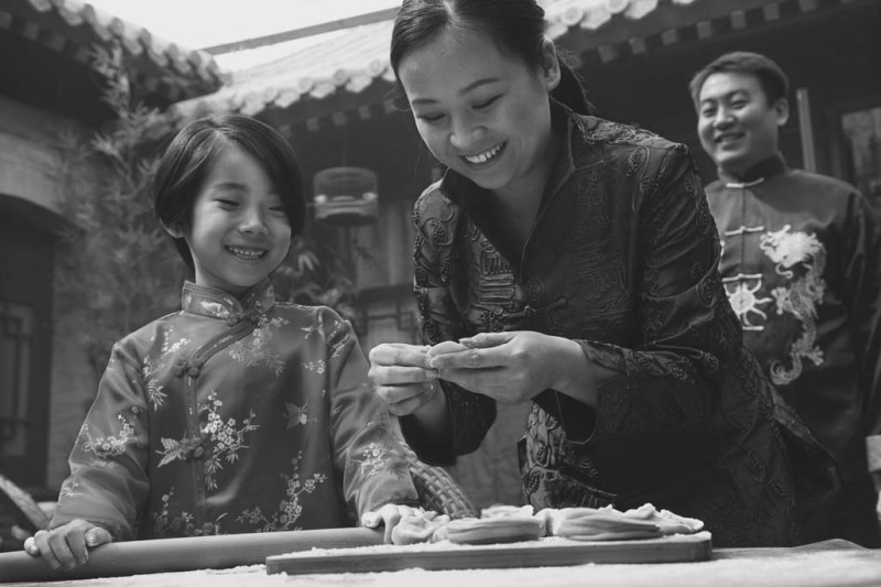 Hai mẹ con làm bánh bao trong trang phục truyền thống