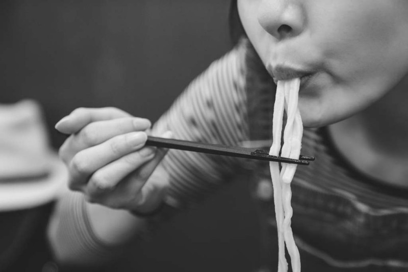 Cận cảnh người phụ nữ ăn mì bằng đũa