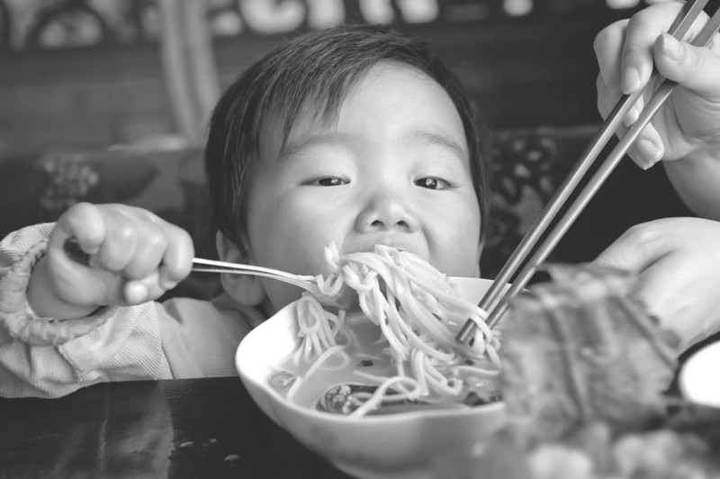 Cận cảnh một đứa trẻ đang ăn mì trong bát
