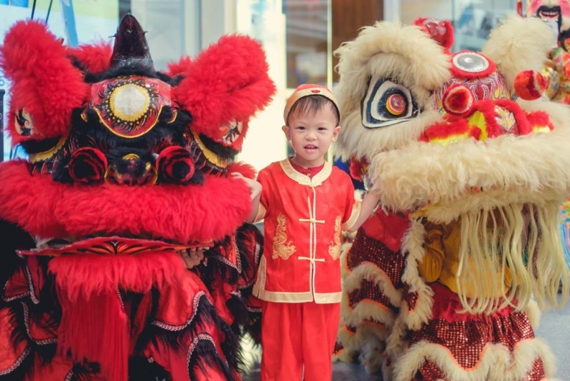 Cậu bé trong trang phục truyền thống màu đỏ của Trung Quốc đón Tết Nguyên đán với màn múa lân Trung Quốc
