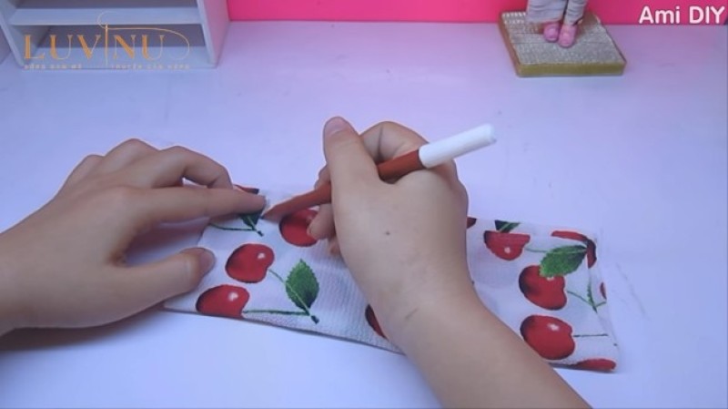 Dùng bút vẽ hình áo dài lên mảnh vải đã được gấp từ trước đó