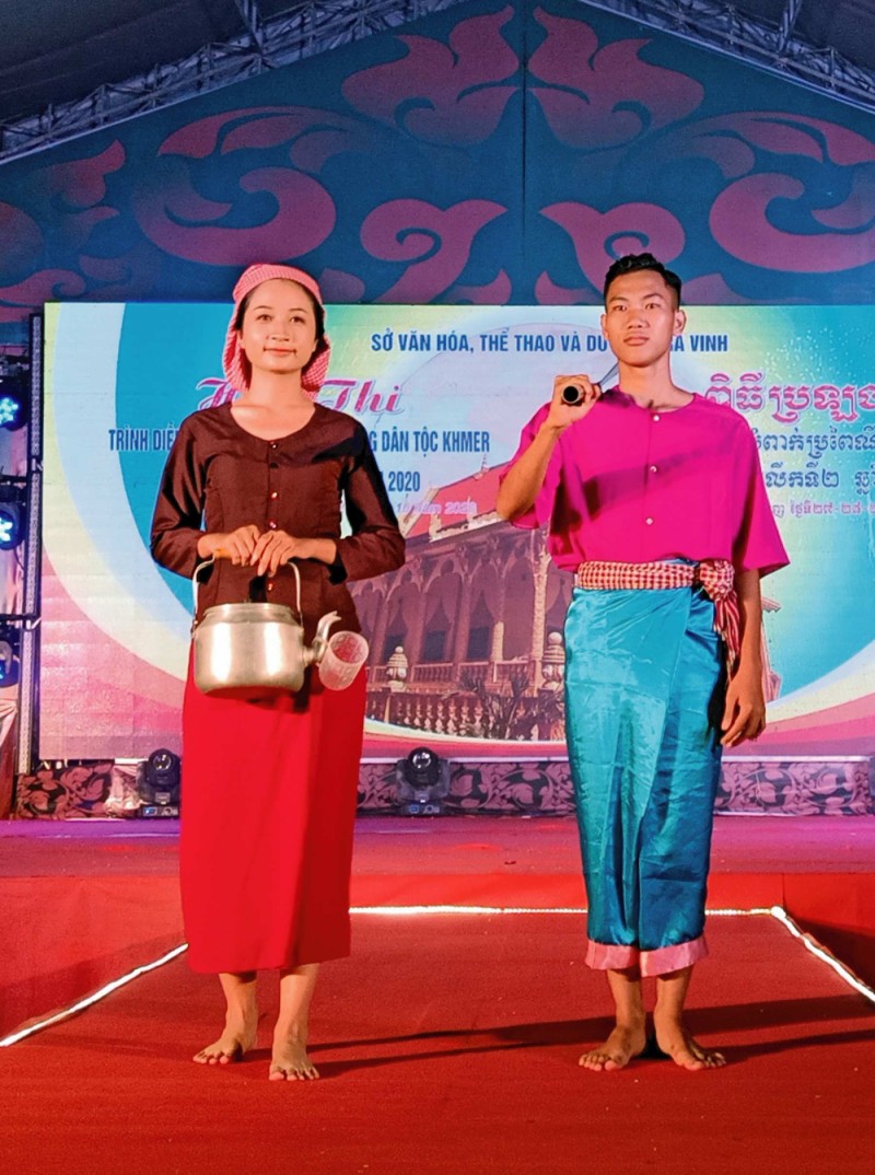 Người lớn tuổi mặc quần áo bà ba tối màu với thêm chiếc khăn đội đầu