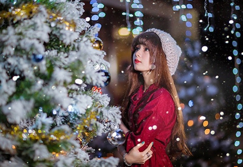 Hai tay khoanh lại và mắt nhìn vào cây thông Noel