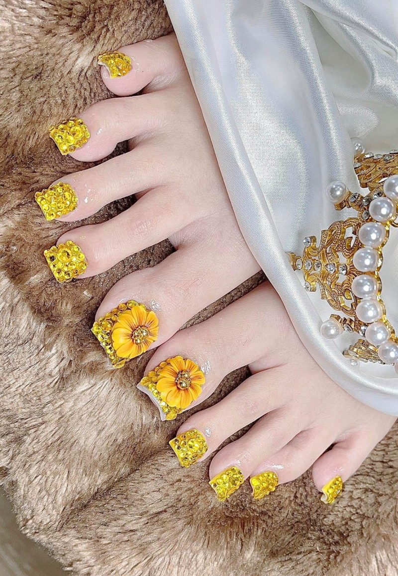 Sơn móng chân màu vàng họa tiết nổi bật 